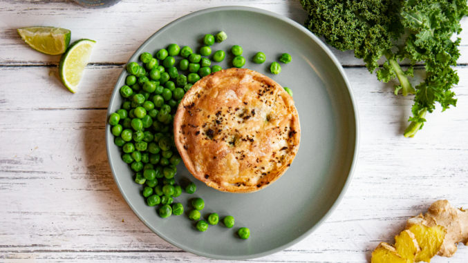 Evergreen Pieminister pie on a plate with peas