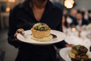 Waiter carrying pies on plates